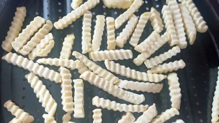 Auf einem Blech legt man die gefrorenen Pommes Frites aus und schiebt sie in den vorgeheizten Backofen. 