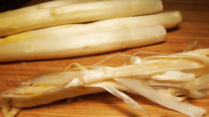 Gestreifter, gesch&auml;lter Spargel liegt auf einem Holzbrett und sieht frisch aus, ideal f&uuml;r die Lagerung.