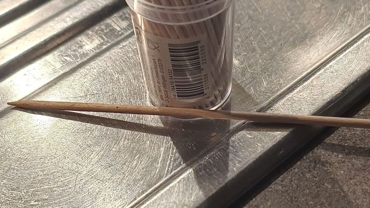 Ein Zahnstocher liegt neben einem Beh&auml;lter auf einer Edelstahloberfl&auml;che, genutzt zum Reinigen schmaler Fugen.