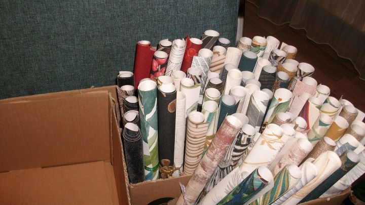 In einer gro&szlig;en Pappschachtel stehen viele dekorative Tapetenrollen. Sie warten darauf, f&uuml;r DIY Gl&uuml;ckwunschr&ouml;llchen verwendet zu werden.