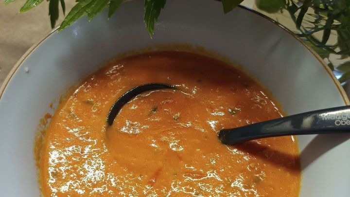 Eine Sch&uuml;ssel Tomatenso&szlig;e mit Kelle auf einem Tisch, umgeben von frischen Kr&auml;utern. Datum in der Ecke: 19. Aug. 2024, 12:30.