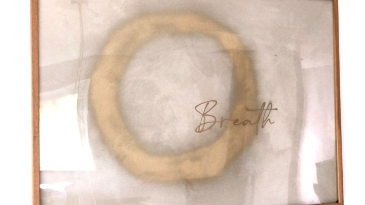 Gerahmtes Bild zeigt stilisierten Kreisen in Gold, dar&uuml;ber steht in eleganter Schrift "Breath", betont Upcycling-DIY.