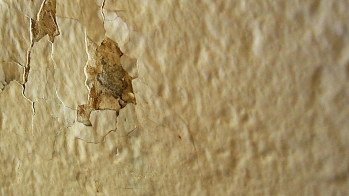 Br&ouml;ckeliger Putz zeigt Risse und Abplatzungen, die das Problem des Haltens von D&uuml;beln erschweren.