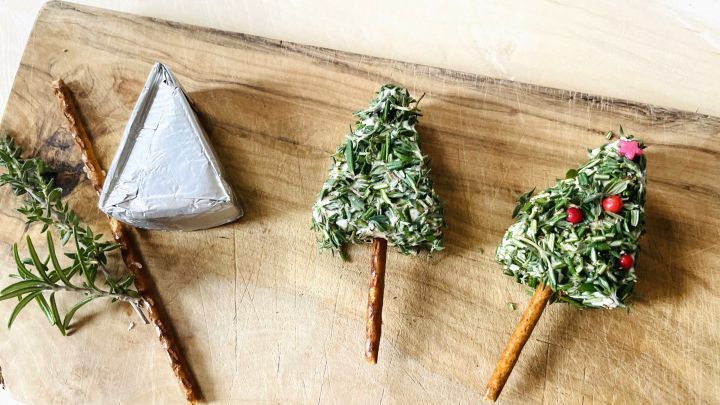 Schneller Snack: Schmelzk&auml;se in Tannenbaumform, dekoriert mit Kr&auml;utern, rotem Pfeffer und Salzstangen als Stiel.