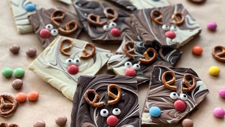 Kreiere k&ouml;stliche Bruchschokolade mit winterlichen Rentieren als festliche Geschenkidee. Die Mischung aus dunkler und wei&szlig;er Schokolade, verziert mit Brezeln und S&uuml;&szlig;igkeiten, begeistert nicht nur optisch. Perfekt f&uuml;r die Weihnachtszeit!