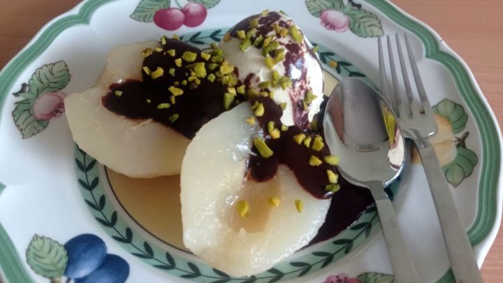 Birne Helene mit Schokoladenso&szlig;e: Ein klassisches Dessert aus saftigen Birnen, verfeinert mit zarter Schokoso&szlig;e und knackigen Pistazien. Perfekt, um deinen Gaumen zu verw&ouml;hnen.