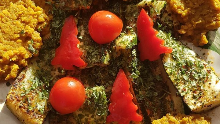 Kreiere einen essbaren Weihnachtsbaum aus Gem&uuml;se: Saftige Tomaten und Paprika als Dekoration, die auf gebackenen Zucchinischeiben ruhen, umgeben von w&uuml;rzigem Linseneintopf. Eine originelle Idee f&uuml;r festlichen Genuss.