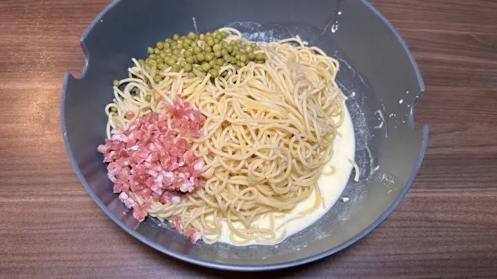 Zu der Sahnemasse d&uuml;rfen jetzt alle anderen Zutaten hineinh&uuml;pfen: Spaghetti, Erbsen und Schinkenw&uuml;rfel.