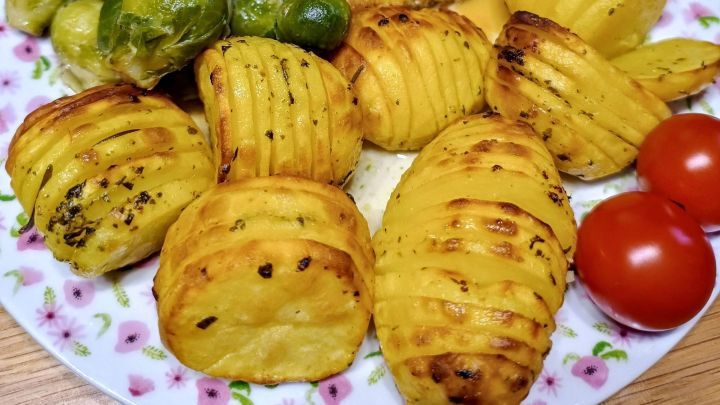 Das Auge isst mit: Leckere Kartoffelf&auml;cher mit Rosmarin frisch aus dem Backofen auf einem Teller angerichtet.