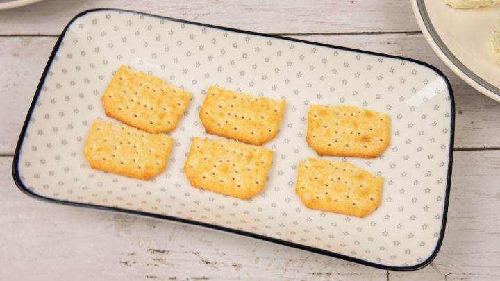 Zuerst legst du die Cracker auf einen Servierteller. Da ich gro&szlig;e Cracker hatte, habe ich sie vorher einmal halbiert.