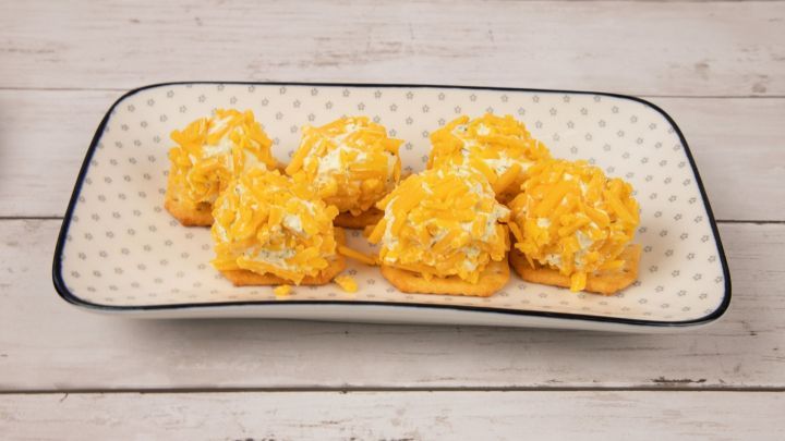 W&auml;lze jetzt die B&auml;llchen vorsichtig im Cheddar. Rolle daf&uuml;r einfach mit den H&auml;nden &uuml;ber den K&auml;se, bis &uuml;berall etwas dran ist.