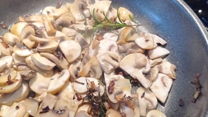 Die Zwiebelw&uuml;rfel und die Knoblauchzehe sowie die Pilze werden in einer Pfanne angebraten und die Kr&auml;uter kommen ebenfalls dazu. 
