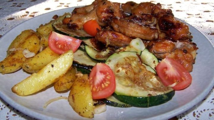 Knusprige Chicken Wings aus dem Airfryer, serviert mit Bratkartoffeln und frischem Gem&uuml;se &ndash; so geht schnelles, leckeres Mittagessen.