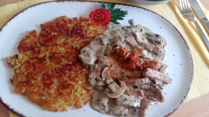 Z&uuml;rcher Geschnetzeltes mit Berner R&ouml;sti: Ein klassisches Schweizer Gericht, angerichtet mit frischem Salat.