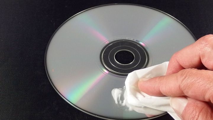 Ein CD wird mit einem Tuch gereinigt, um Kratzer zu beseitigen und sie wieder spielbar zu machen.