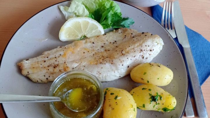 Die Zander-Filets werden auf den Tellern mit der Estragon-Zitronen-Butter &uuml;bergossen und mit den Petersilienkartoffeln angerichtet.
