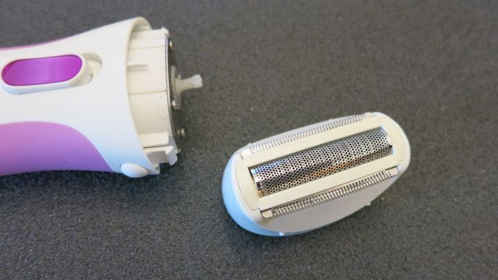 Die Klinge eines Trockenrasierers liegt neben dem Ger&auml;t und wird gerade mit Gebissreiniger gereinigt.