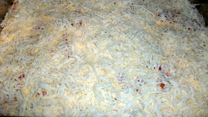 Dann den Frischk&auml;se mit Sahne, Eier und Gew&uuml;rzen gut verr&uuml;hren und &uuml;ber den Auflauf verteilen. Danach gleichm&auml;&szlig;ig K&auml;se dar&uuml;ber streuen.