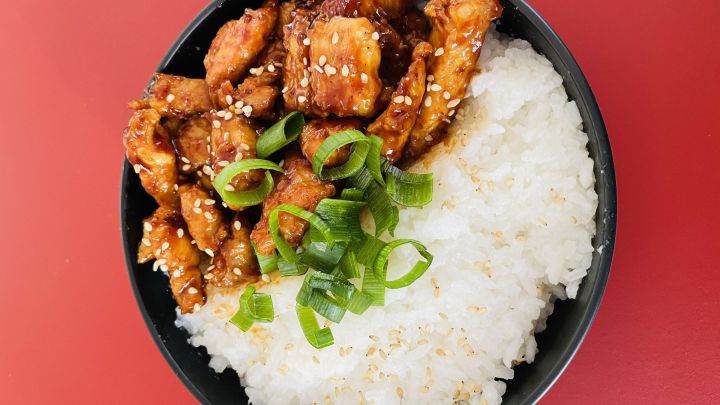 Saftige karamellisierte H&auml;hnchenbrust trifft auf lockerem Reis, garniert mit Sesam und Fr&uuml;hlingszwiebeln &ndash; asiatischer Genuss.