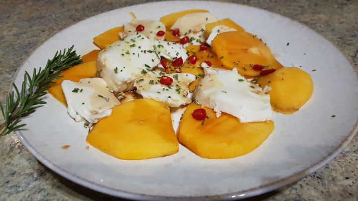 Mit dieser Variation bringst du Abwechslung in deinen Caprese-Salat: Sharonfrucht mit Chilis und Rosmarinnadeln.