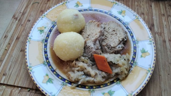 Ein sch&ouml;nes St&uuml;ck Schweinebraten auf buntem Gem&uuml;se mit viel Knoblauch, Zwiebeln und Karotten &ndash; und nat&uuml;rlich d&uuml;rfen die Kartoffelkn&ouml;del nicht fehlen.