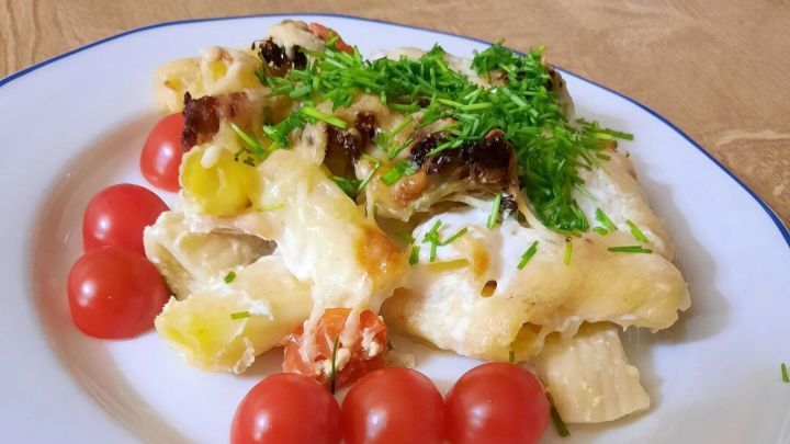 Rigatoni-Auflauf mit Hack, Schinken und Gem&uuml;se auf einem Teller angerichtet.