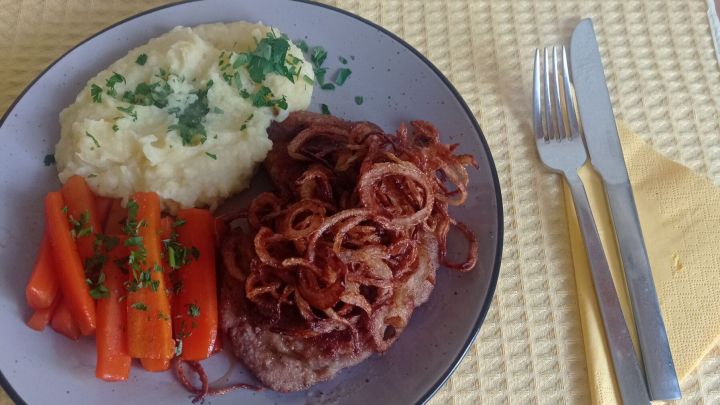 Angerichtet werden die Holzf&auml;ller-Steaks mit den Zwiebeln, Kartoffelp&uuml;ree und den karamellisierten M&ouml;hren.