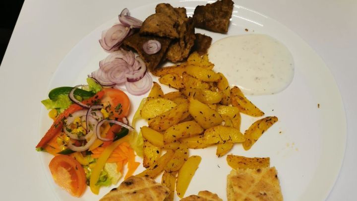 Unser selbstgemachter D&ouml;nerteller mit Kartoffelspalten, Fladenbrot, Salat und Joghurt-Knoblauch-Dip.