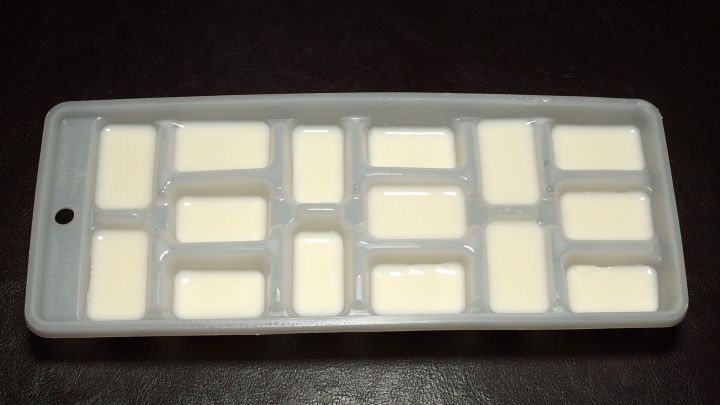 Ein Silikonbeh&auml;lter mit kleinen F&auml;chern enth&auml;lt frische Sahne, bereit zum Portionieren in der K&uuml;che.