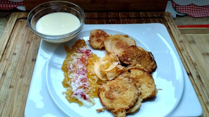 Apfelringe im Teigmantel mit Vanilleso&szlig;e aus dem Rezept: knusprig gebacken, mit Fruchtstreifen und Apfelsp&auml;nen stilvoll angerichtet