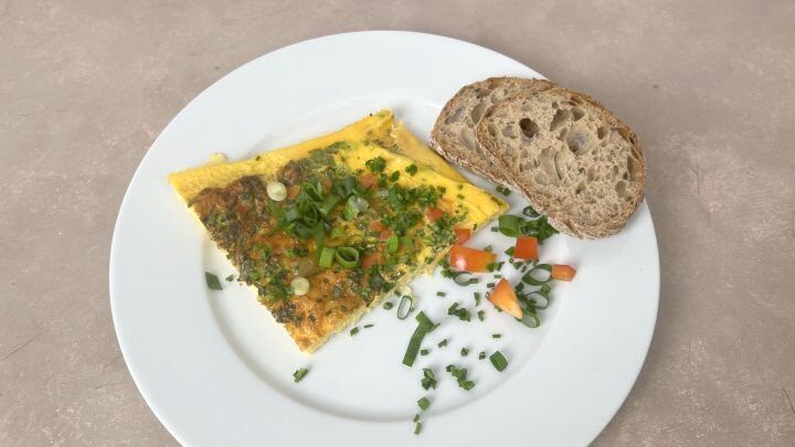 Omelett aus dem Airfryer mit Schnittlauch und Fr&uuml;hlingszwiebeln, dazu Brot &ndash; fluffiges Airfryer-Omelett f&uuml;r ein schnelles Fr&uuml;hst&uuml;ck.