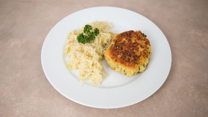 Original Kaspresskn&ouml;del aus &Ouml;sterreich, knusprig gebraten und serviert mit Sauerkraut und frischer Petersilie.