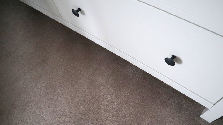 Ein wei&szlig;er Schrank mit schwarzen Griffen wird auf einem Teppich mithilfe von Essst&auml;bchen verschoben, um den Boden schonend zu behandeln.