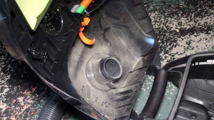 Ein Staubsaugerbeutel liegt in einem Sauberkeitskontext, w&auml;hrend der Staubsauger aufgeklappt ist, um ihn zu entleeren.