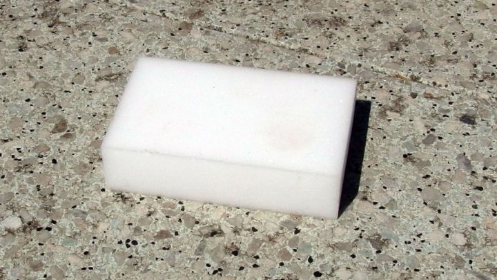 Ein Schmutzradierer liegt auf einer beton&auml;hnlichen Steinterrasse, bereit, Schmutzflecken zu entfernen.