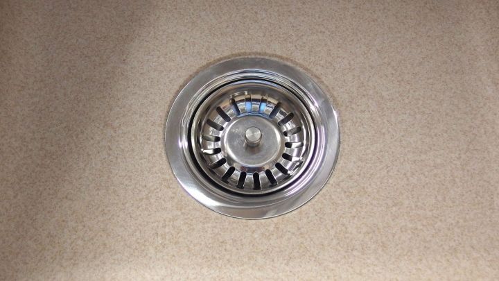 Ein Abflusssieb in einer Sp&uuml;le, sichtbar in der Mitte, wartet darauf, mit einem Schmutzradierer gereinigt zu werden.