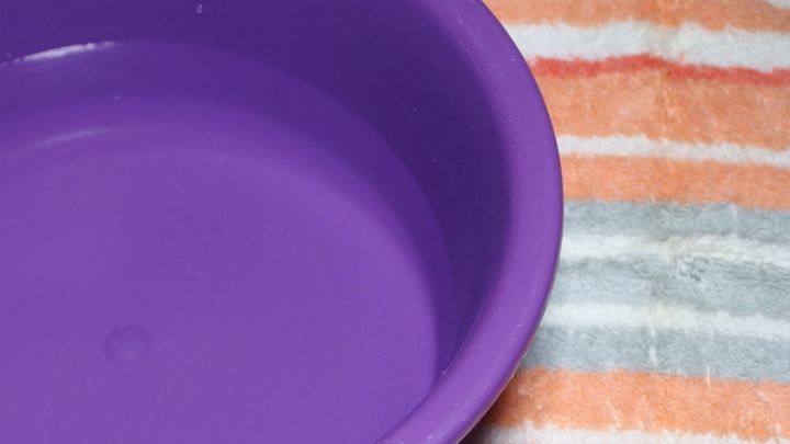 Ein lila Gesichtsdampfbad steht auf einem gestreiften Handtuch, ideal f&uuml;r die Anwendung gegen Pickel und zur Hautreinigung.