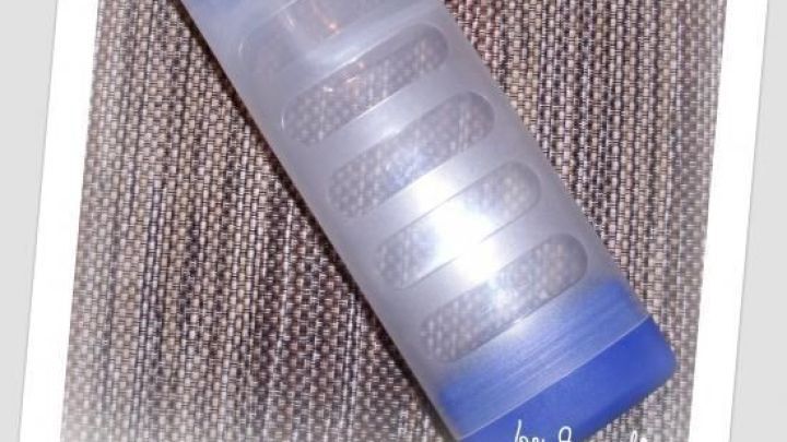 Eine transparente Nasendusche mit blauem Deckel liegt auf einem gestreiften Stoff. In der Ecke steht "by Angelina".