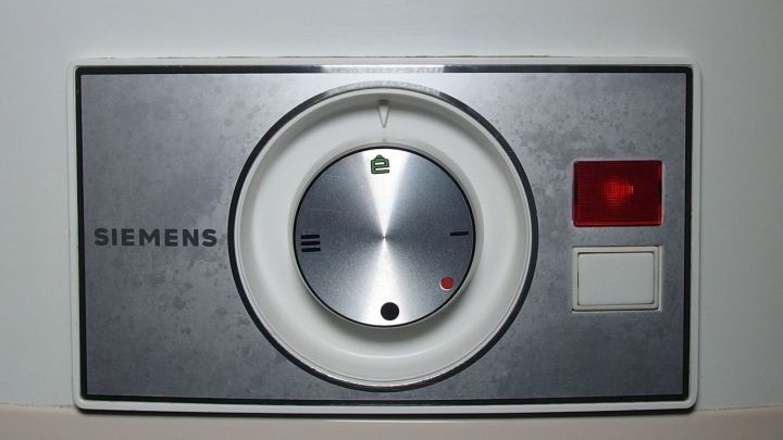 Ein runder Drehregler an einem silbernen Geh&auml;use steuert das Duschen, um Energie zu sparen. Daneben befindet sich ein rotes Licht.