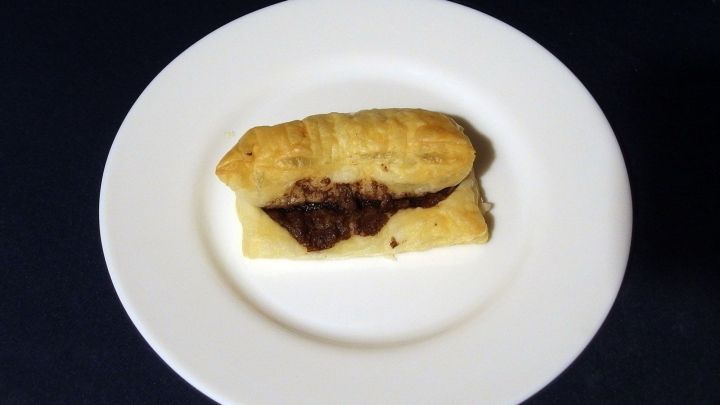 Ein warmes s&uuml;&szlig;es St&uuml;ckchen auf einem wei&szlig;en Teller, gef&uuml;llt mit einer k&ouml;stlichen Schokoladenf&uuml;llung.