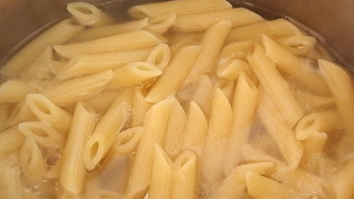 Pasta kocht in einem Topf mit sprudelndem Wasser, um Strom zu sparen beim Nudeln kochen.