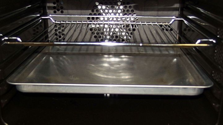Ein Backblech und ein Grillrost liegen in einem Ofen, bereit zur schonenden Reinigung ohne Kratzen.
