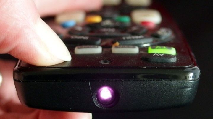 Eine Hand h&auml;lt eine Fernbedienung, w&auml;hrend sie die Funktions&uuml;berpr&uuml;fung durch den leuchtenden Infrarotstrahl testet.