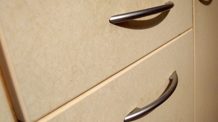 Eine Schublade mit Metallgriffen, die f&uuml;r die Beseitigung von Hartn&auml;ckiger Fettschmiere geeignet ist, in einem hellen K&uuml;chenumfeld.