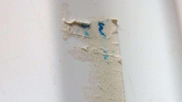 Ein besch&auml;digter Wandbereich mit Kleberesten zeigt, dass M&ouml;belpolitur zur Entfernung verwendet werden kann.