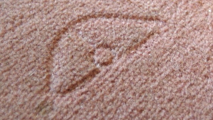 Ein Teppich mit einer deutlichen M&ouml;beldruckstelle, die sichtbar in der Struktur des Materials eingedr&uuml;ckt ist.