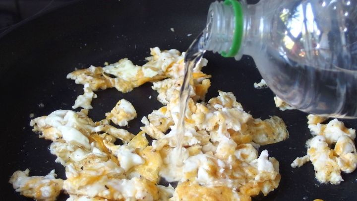 Weiches R&uuml;hrei wird in einer Pfanne zubereitet, w&auml;hrend Wasser hineingegossen wird, um es noch zarter zu machen.