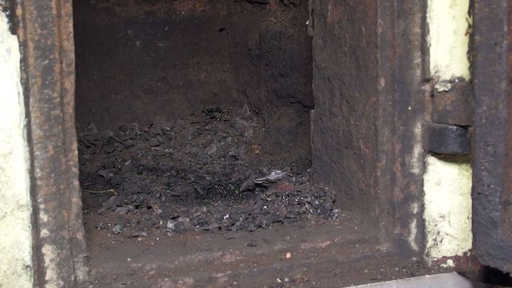 Ein offenes Schornsteinfach zeigt Ru&szlig;ablagerungen, die genutzt werden, um Schnecken abzuschrecken und abzuwehren.