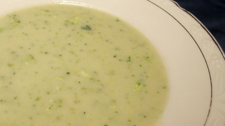 Eine cremige Suppe ist in einer eleganten Sch&uuml;ssel angerichtet. Die gr&uuml;ne Farbe deutet auf frische Zutaten hin.