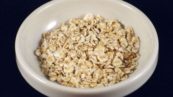 Eine Schale mit Haferflocken steht auf einem dunklen Untergrund, bereit zur Zubereitung gegen Sodbrennen.